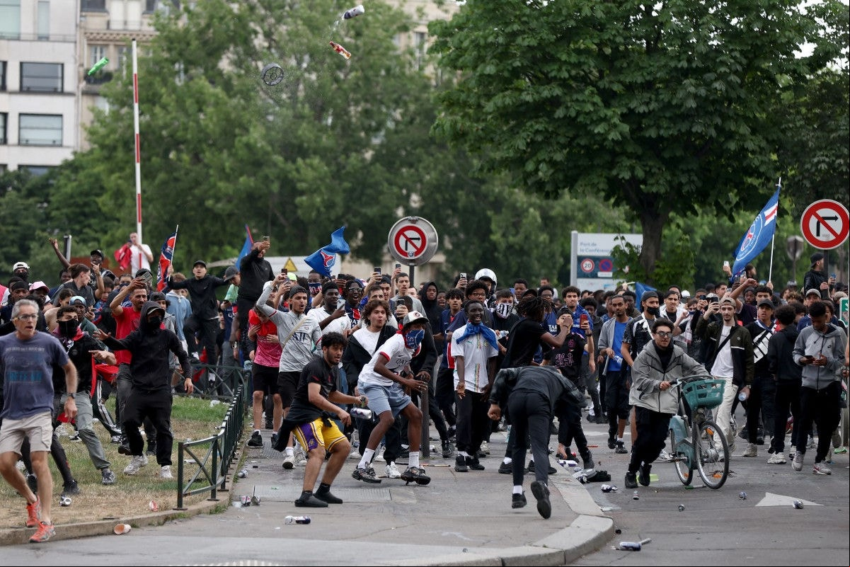 Crowd clashes with police officers following the PSG team bus parade, near the Champs-Elysees avenue in Paris on June 1, 2025, a day after PSG won the 2025 UEFA Champions League final football match against Inter Milan in Munich. (Photo by Romain PERROCHEAU / AFP)