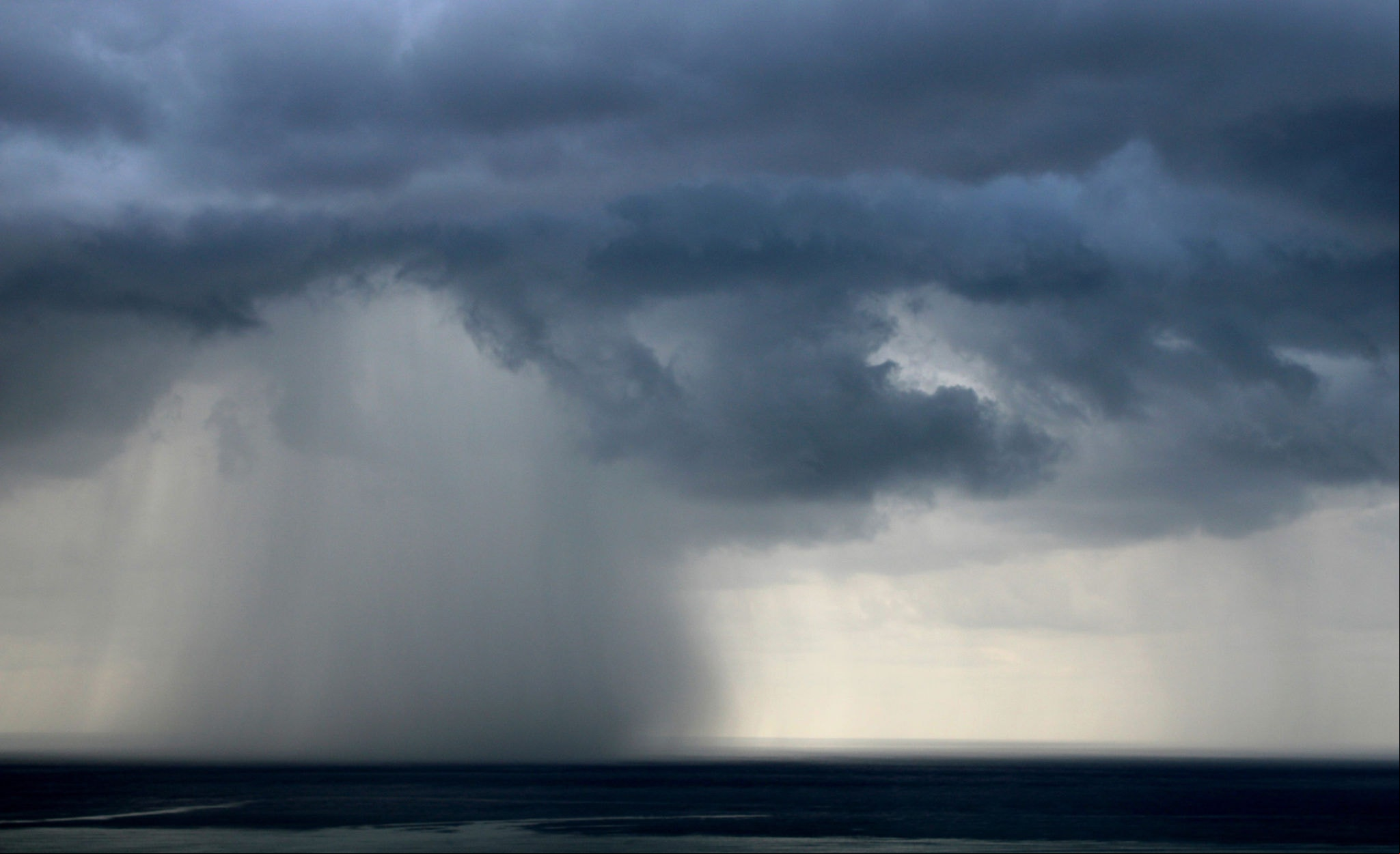 Storm clouds over the sea, dark sky overcast in summer, torrential rain