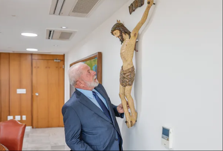O presidente da República, Luiz Inácio Lula da Silva (PT), com a escultura de Cristo restaurada no gabinete presidencial 