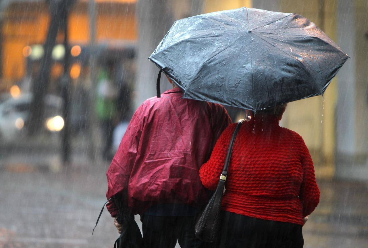 Pedestres se protegem do frio e da chuva em BH