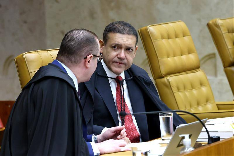 O ministro do STF Kassio Nunes Marques (de frente) em conversa no plenário com Cristiano Zanin (de costas)