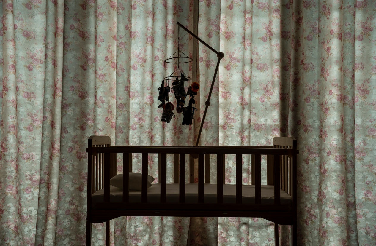 Baby crib mobile attached to a baby cot
