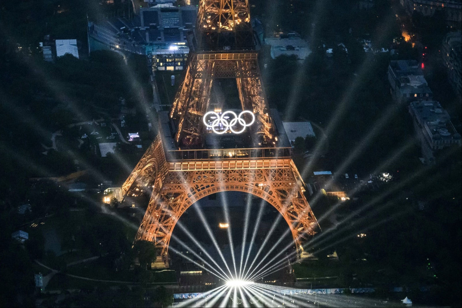 Uma fotografia tirada de um helicóptero em 26 de julho de 2024 mostra uma vista aérea da Torre Eiffel e dos Anéis Olímpicos iluminados durante a cerimônia de abertura dos Jogos Olímpicos de Paris 2024 em Paris.