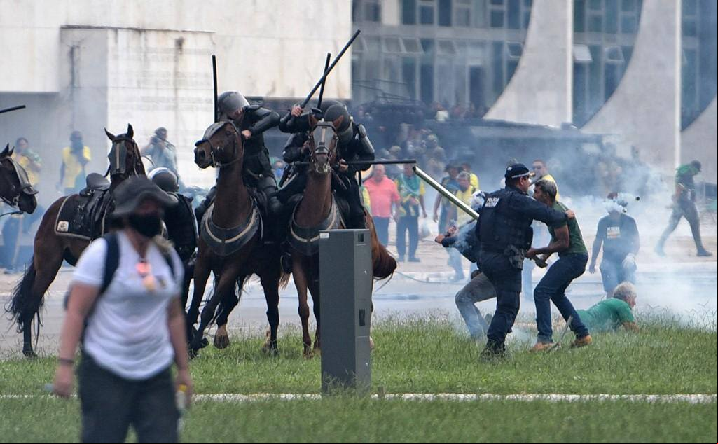 Apoiadores do ex-presidente Jair Bolsonaro agridem policiais militares que estavam em cavalos na Praça dos Três Poderes em 8 de janeiro de 2023