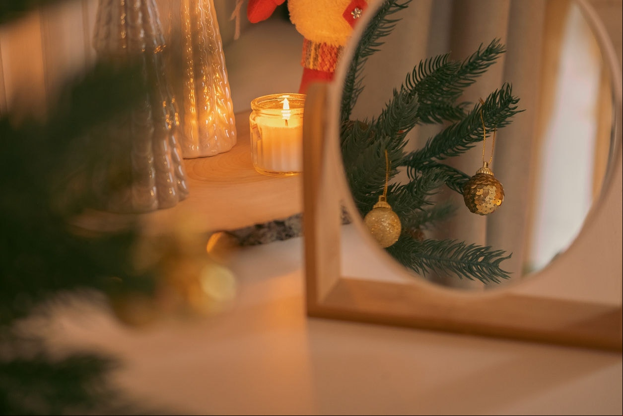 Beautiful and decorated Christmas tree in the mirror reflection. Christmas mood. Great photo for greeting card. Boho Scandinavian Style Design. Close up of Christmas tree adorning. New Year decoration